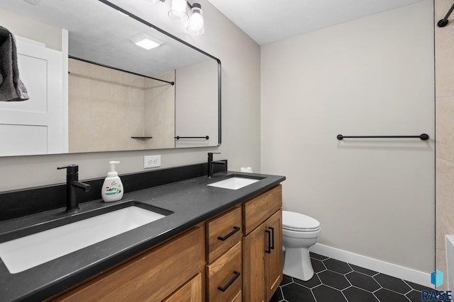 2704 S Snow Mass Ave, Sioux Falls, SD 57110 - bathroom with double vanity, toilet, tile patterned flooring, and baseboards