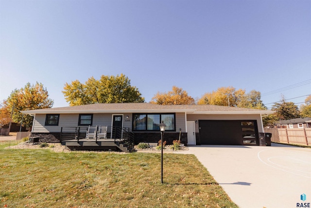 single story home with a wooden deck, a front lawn, and a garage