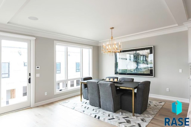 dining area featuring hardwood / wood-style floors, an inviting chandelier, and ornamental molding