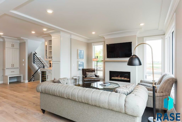 living room with wine cooler, light hardwood / wood-style flooring, and ornamental molding