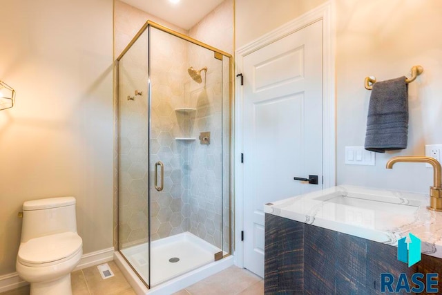 bathroom featuring tile patterned floors, toilet, a shower with door, and sink