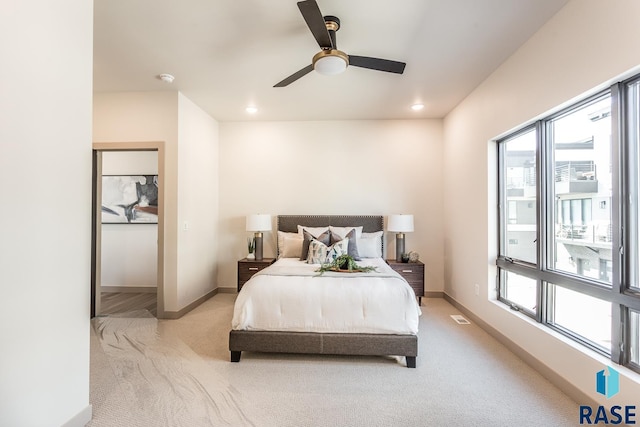 carpeted bedroom with multiple windows and ceiling fan