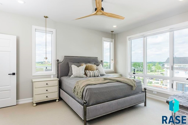 bedroom with ceiling fan and light carpet