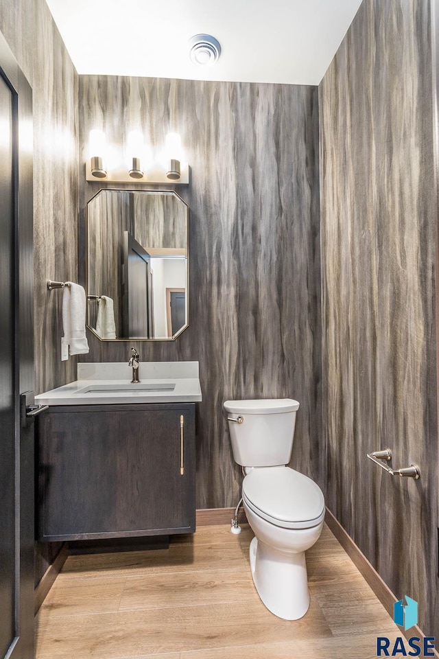 bathroom featuring vanity, wood-type flooring, and toilet