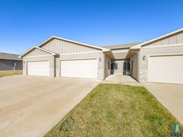 ranch-style home featuring a garage and a front lawn