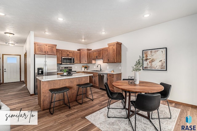 kitchen featuring sink, a center island, dark hardwood / wood-style floors, and appliances with stainless steel finishes