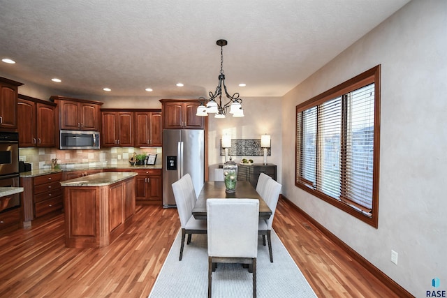 dining room featuring a textured ceiling, dark hardwood / wood-style floors, and a notable chandelier