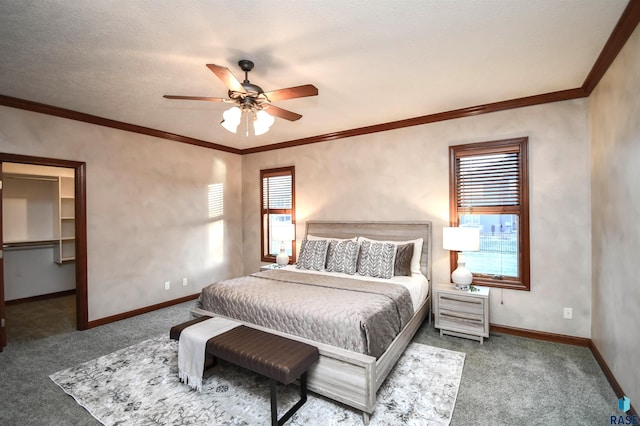 carpeted bedroom featuring ceiling fan, a spacious closet, a textured ceiling, and multiple windows