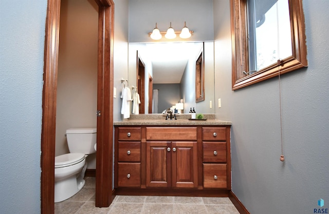 bathroom with tile patterned flooring, vanity, and toilet