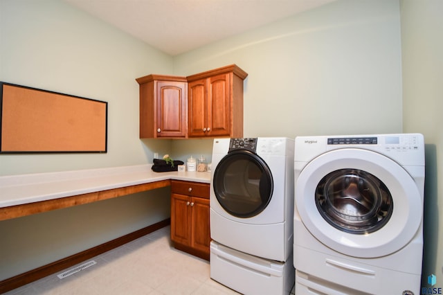 washroom with washer and dryer and cabinets