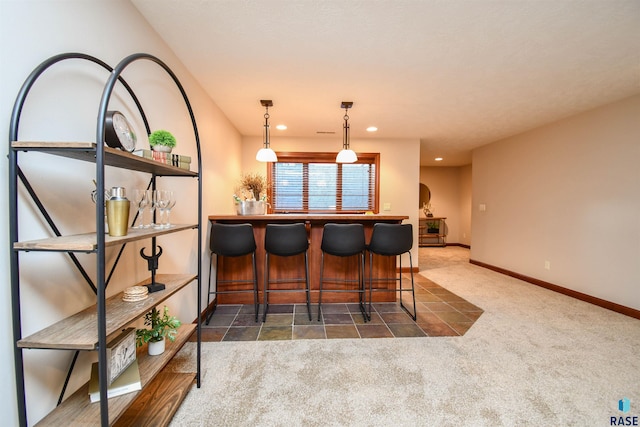 bar with dark carpet and hanging light fixtures