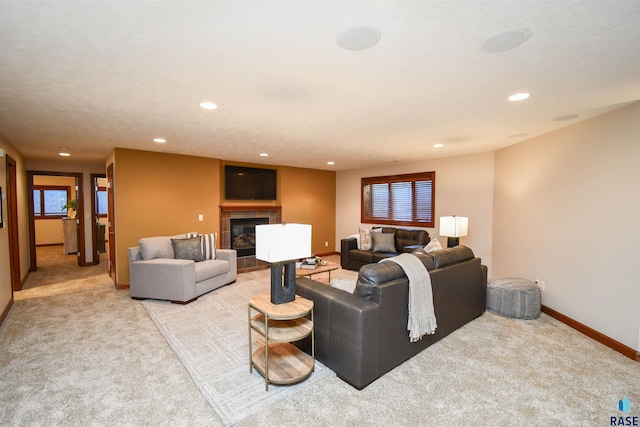 living room featuring light carpet, a fireplace, and a textured ceiling