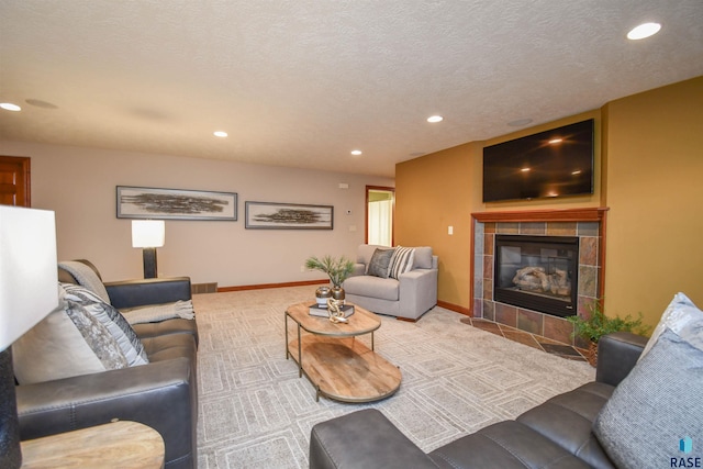 carpeted living room featuring a textured ceiling and a tiled fireplace