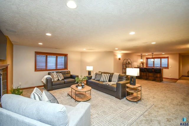 carpeted living room with a fireplace, indoor bar, and a textured ceiling