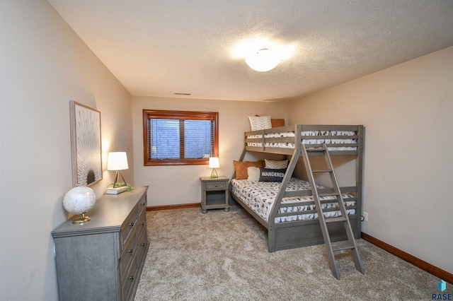 bedroom with a textured ceiling and light colored carpet