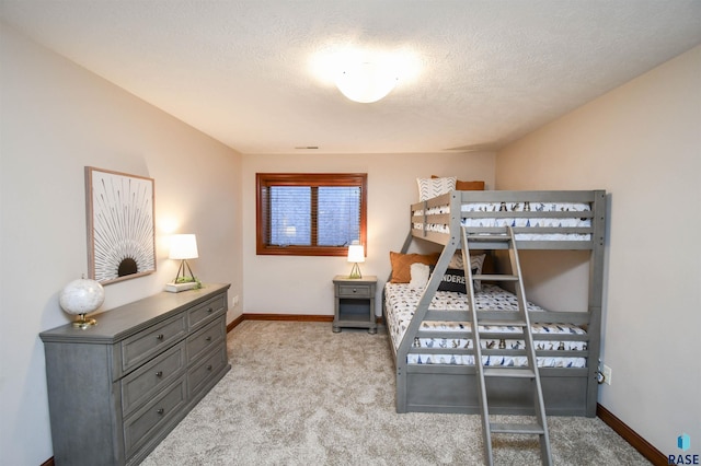 bedroom with light carpet and a textured ceiling