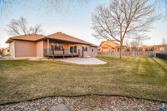 rear view of property with a yard, a patio, and a deck