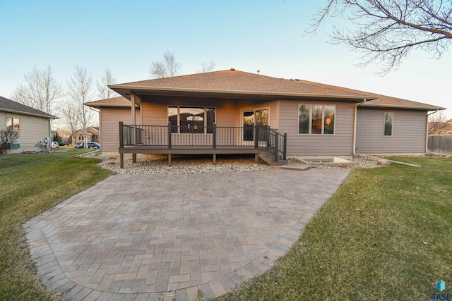 view of front facade featuring a wooden deck and a front yard