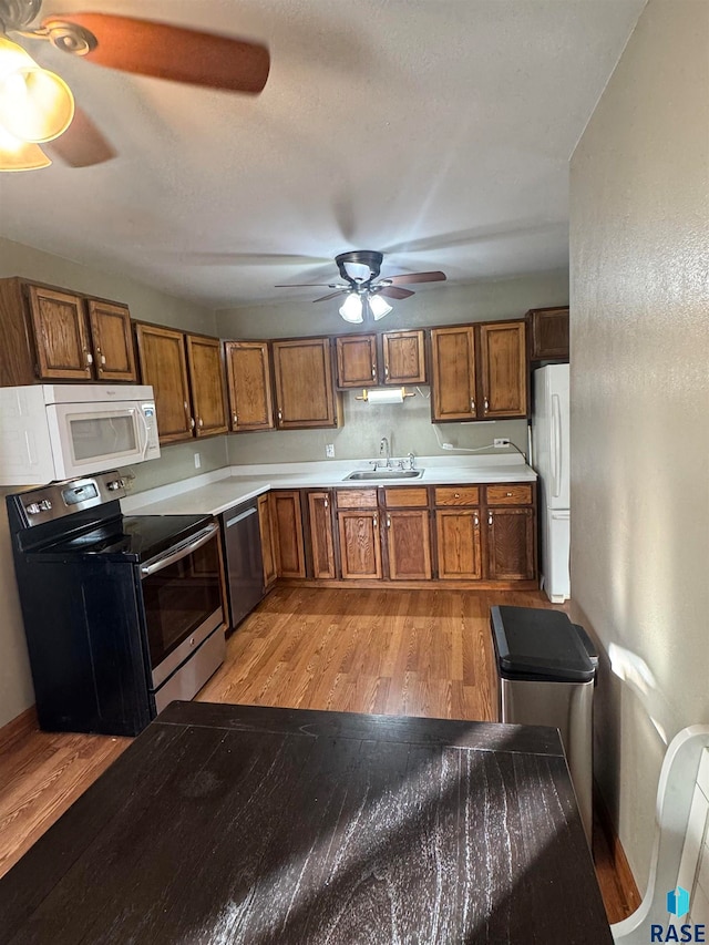 kitchen featuring stainless steel appliances, light hardwood / wood-style floors, and sink