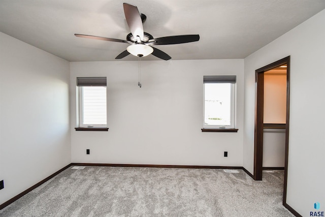 carpeted spare room with ceiling fan