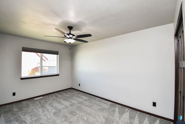 carpeted empty room with a textured ceiling and ceiling fan