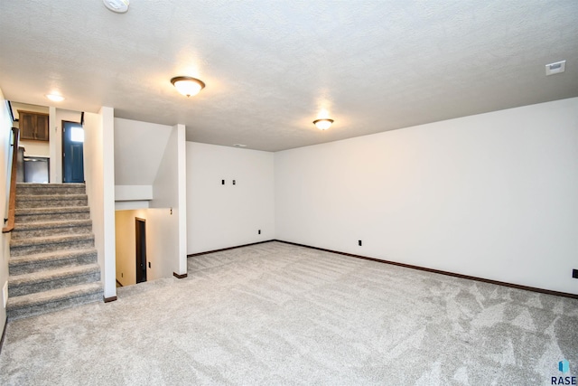 basement with light carpet and a textured ceiling