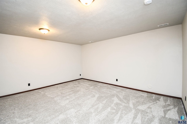 carpeted empty room with a textured ceiling