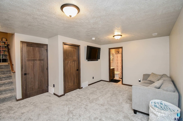 sitting room featuring a textured ceiling and light colored carpet