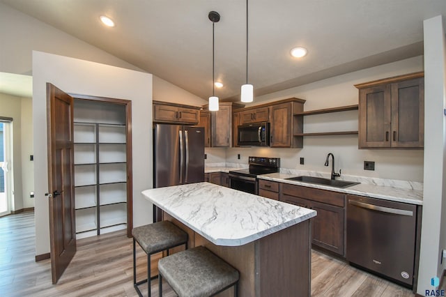 kitchen with sink, light hardwood / wood-style flooring, vaulted ceiling, decorative light fixtures, and stainless steel appliances