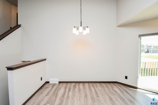 unfurnished dining area with light hardwood / wood-style flooring and an inviting chandelier