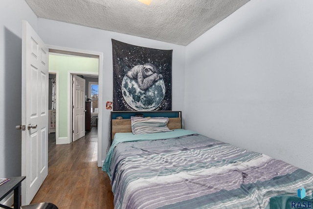 bedroom with a textured ceiling and dark wood-type flooring