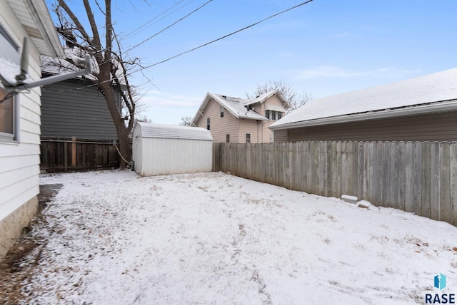 yard layered in snow with a storage shed