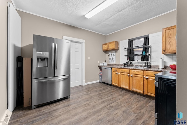 kitchen with sink, dark hardwood / wood-style flooring, ornamental molding, and stainless steel appliances