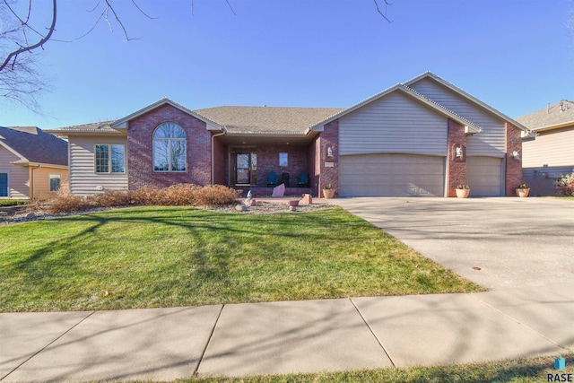 ranch-style house featuring a garage and a front lawn