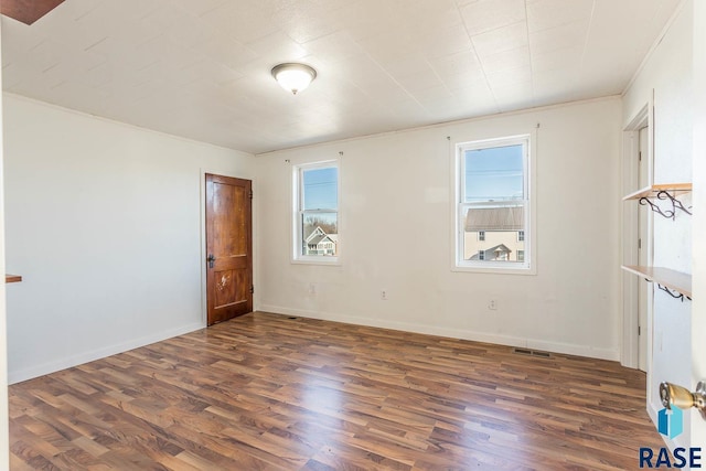 spare room with dark hardwood / wood-style floors and ornamental molding