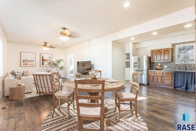 dining room with ceiling fan, dark hardwood / wood-style flooring, and sink