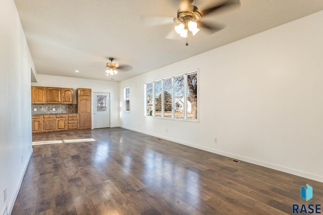 unfurnished living room with ceiling fan and dark hardwood / wood-style floors