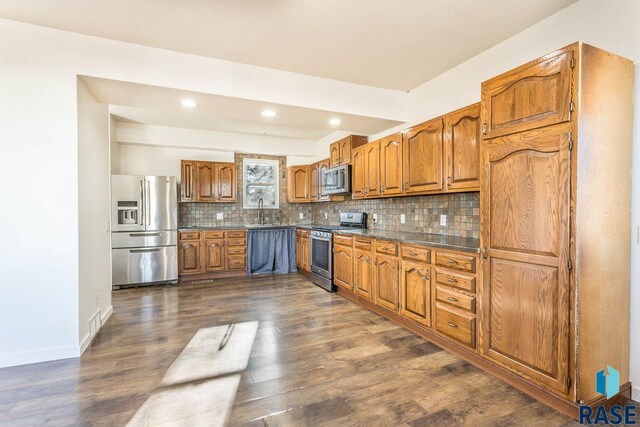 kitchen with backsplash, stainless steel appliances, dark wood-type flooring, and sink