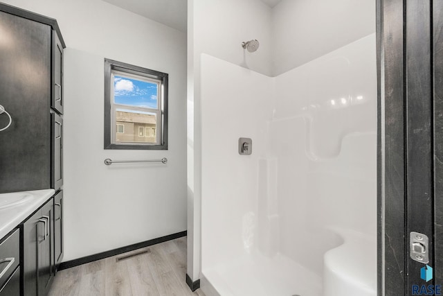 bathroom featuring a shower, sink, and hardwood / wood-style flooring