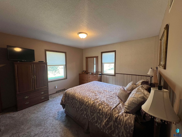 carpeted bedroom featuring a textured ceiling and wooden walls