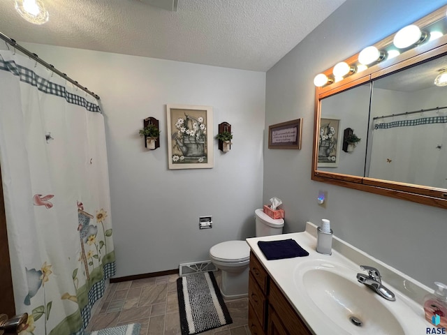 bathroom with vanity, tile patterned flooring, toilet, a textured ceiling, and walk in shower