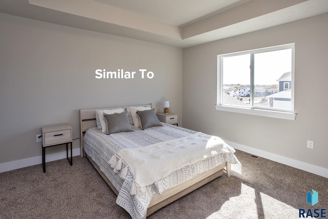 carpeted bedroom with a tray ceiling