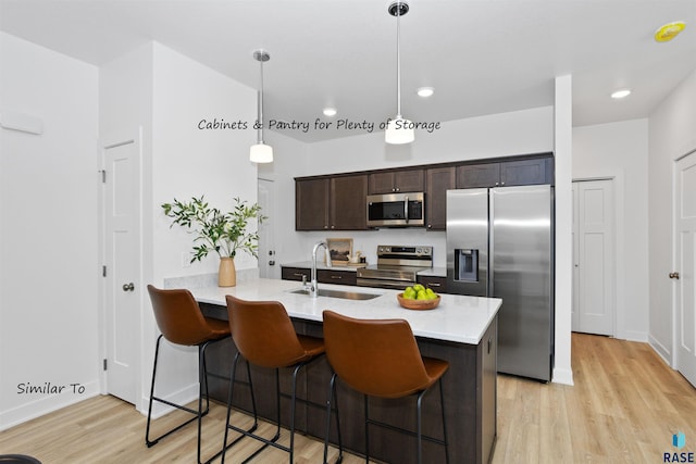 1271 N Marion Rd Unit 2, Sioux Falls, SD 57107 - kitchen featuring stainless steel appliances, a sink, light wood finished floors, dark brown cabinets, and a breakfast bar