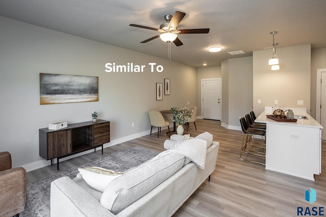 living room with ceiling fan and light hardwood / wood-style flooring