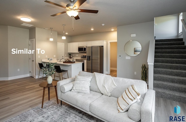 living room featuring light wood-type flooring and ceiling fan