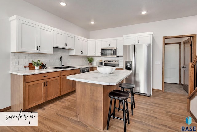 kitchen featuring white cabinetry, a kitchen island, light hardwood / wood-style floors, and appliances with stainless steel finishes