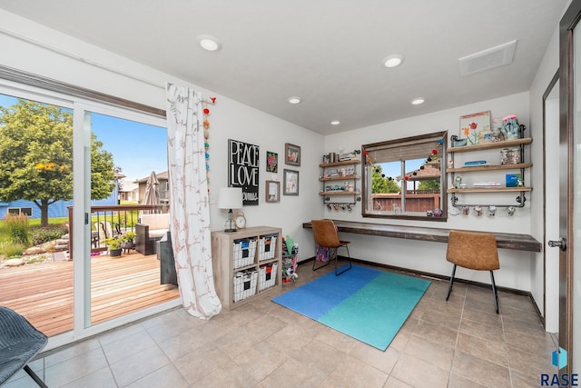 game room featuring built in desk, a wealth of natural light, and light tile patterned flooring