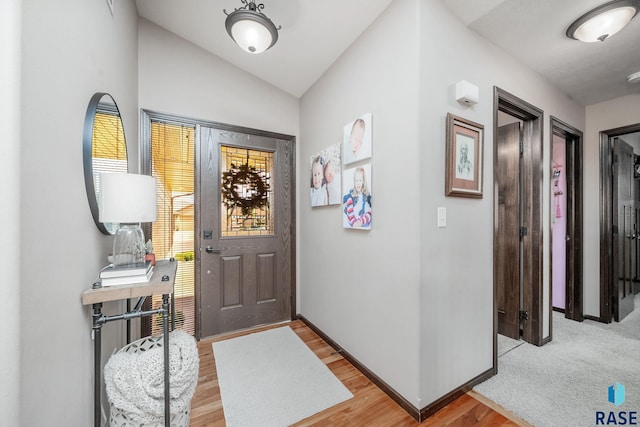 entrance foyer with light hardwood / wood-style flooring and lofted ceiling