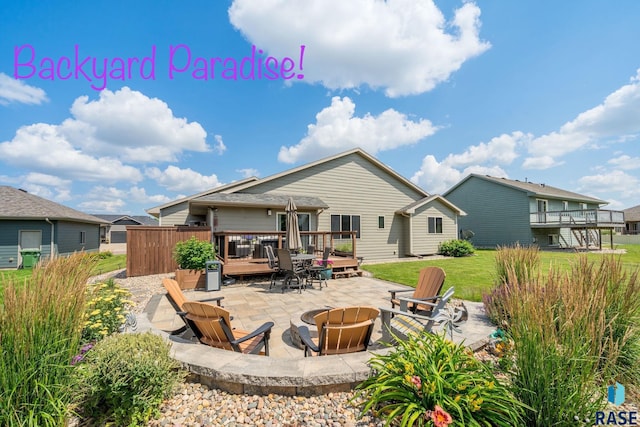 rear view of property featuring an outdoor fire pit, a patio area, and a wooden deck