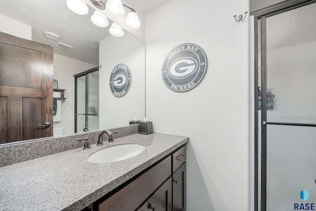 bathroom with vanity and a shower with door